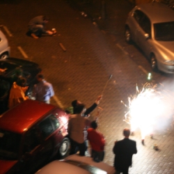 fêtards dans la rue avec une fontaine de lumière